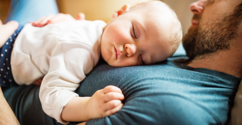 Baby sleeping on dads chest during paternity leave